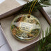 A decorative ornament featuring a scenic image of Grizzly Creek in the Redwoods State Park, California.