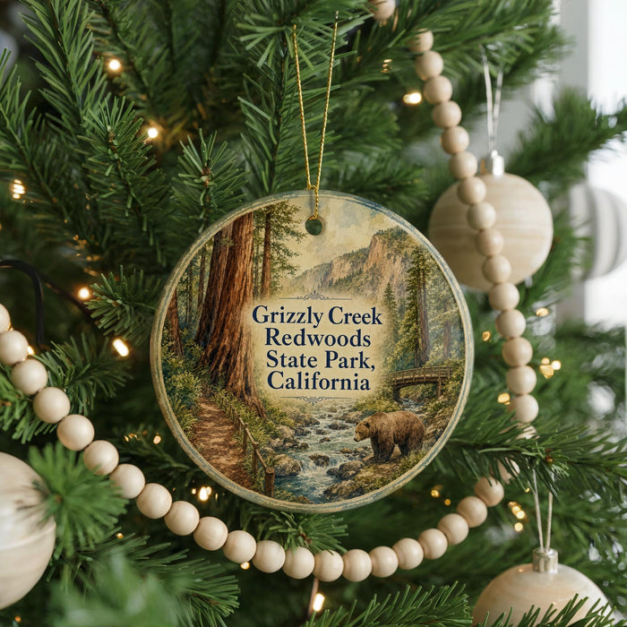 A round ornament hanging on a Christmas tree, featuring a scenic image of Grizzly Creek and Redwoods State Park in California.