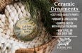 Ceramic ornaments, featuring a bird and a landscape scene, are displayed in a basket with greenery.