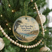 A round ornament hanging on a Christmas tree, featuring a scenic image of Half Moon Bay, California.