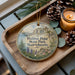 A wooden tray with a decorative ornament featuring a scenic image of Halibut Point State Park, Massachusetts, and pine cones.