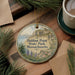 A round ornament with a scenic image of Halibut Point State Park, Massachusetts, hanging on a wooden surface.
