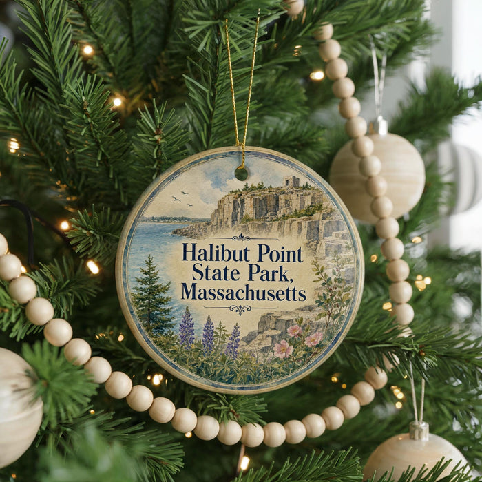 A circular ornament hanging on a Christmas tree, featuring a scenic image of Halibut Point State Park in Massachusetts.