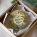 A decorative ornament in a white box, featuring a scenic landscape with birds, a deer, and a pond.