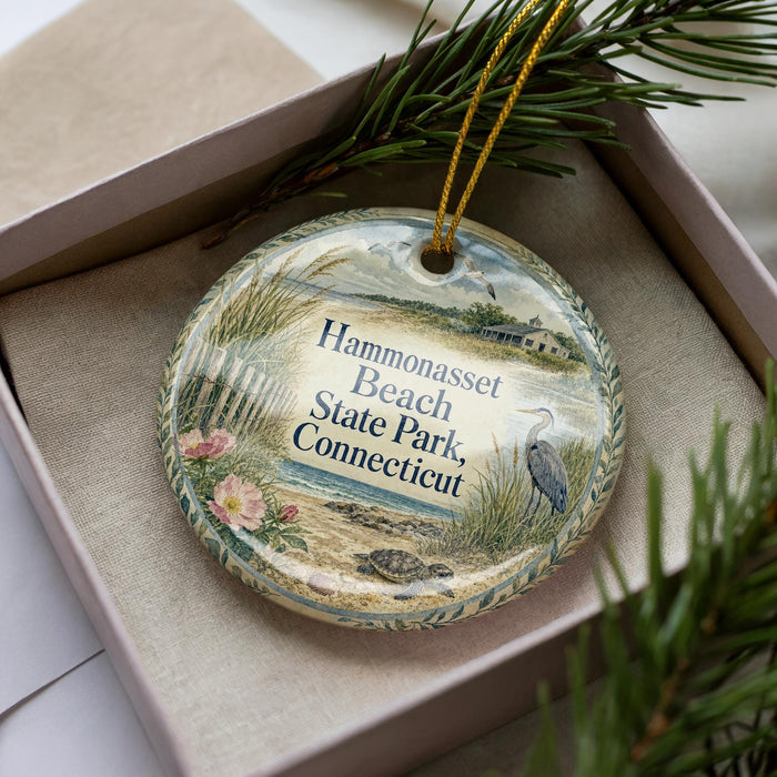 A decorative ornament in a box, featuring a beach scene with a bird and flowers, and the text "Hammonasset Beach State Park Connecticut".