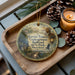 A decorative ornament featuring a scenic image of Harriet Tubman, the Underground Railroad Railroad, and the State Park in Maryland, with a lantern and pine cones on a wooden tray.