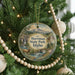 A round ornament hanging on a Christmas tree, featuring a scenic image of Harriman State Park, Idaho.
