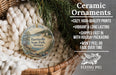 Ceramic ornaments, including a round ornament with a scenic landscape, are displayed in a basket with pine branches.