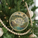 A round ornament hanging on a Christmas tree, featuring a scenic image of Hawaii.