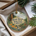 A round ornament with a forest scene and a deer, hanging from a string.