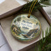 A decorative ornament with a scenic landscape of a mountain and river, featuring the text "Heyburn State Park, Idaho" on it.