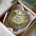 A decorative ornament in a box, featuring an illustration of Illinois State Park and a deer.
