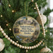 A round ornament hanging on a Christmas tree, featuring an illustration of Independence Mine and Historical Park in Alaska.