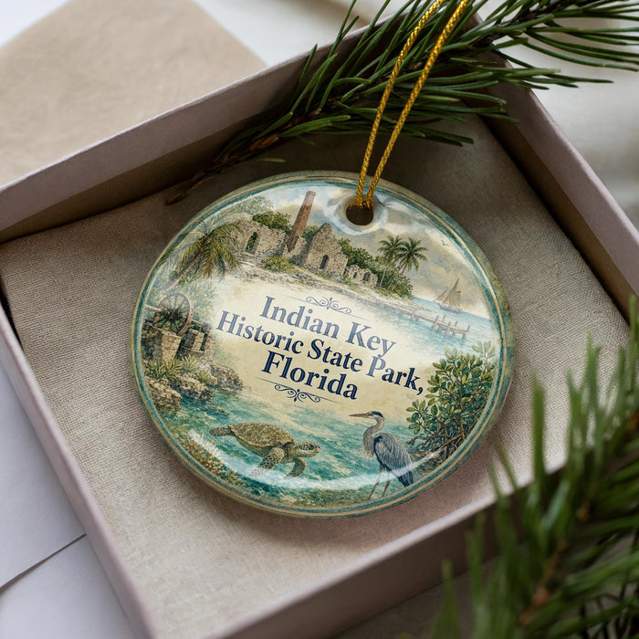 A decorative ornament in a box, featuring illustrations of a historic site and tropical elements, with the text "Indian Key Historic State Park, Florida" prominently displayed.