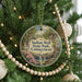 A round ornament hanging on a Christmas tree, featuring a scenic image of Indian Well State Park in Connecticut.