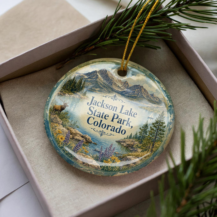 A decorative ornament featuring a scenic landscape of Jackson Lake, Colorado, with mountains, pine trees, and a body of water.