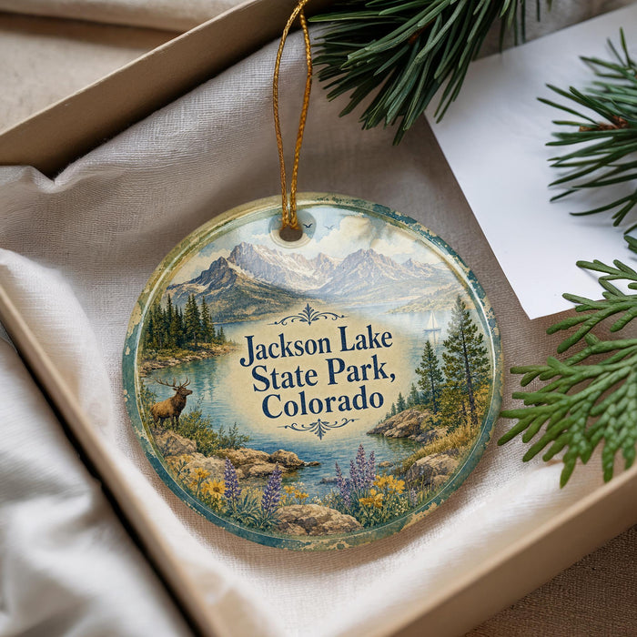 A decorative ornament with a scenic landscape of Jackson Lake State Park, Colorado, featuring mountains, pine trees, and a lake.