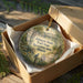 A decorative ornament in a box, featuring a scenic image of a trail in the Johnson-Sauk Trail State Recreation Area, Illinois.