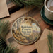 A circular ornament with a scenic image of the Kartchner Caves in Arizona, featuring a desert landscape with a cactus and a mountain range.