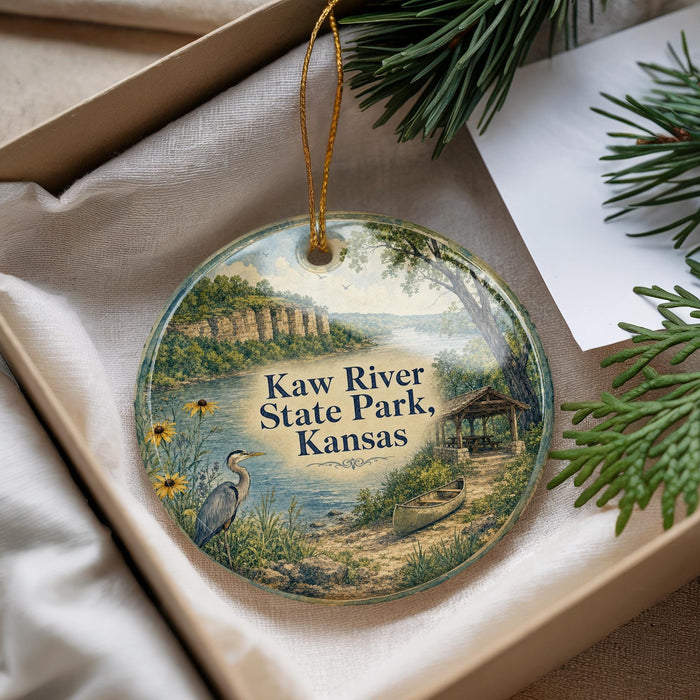 A decorative ornament with a scenic image of Kaw River State Park, Kansas, featuring a bird, a canoe, and a cabin.