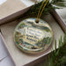 A decorative ornament in a box, featuring a scenic image of Kentucky's Kentucky State Resort Park.
