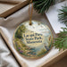 A decorative ornament with a scenic landscape of Lacquis Parle State Park, Minnesota, featuring a bird, a path, and a body of water.