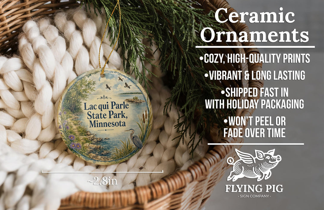 Ceramic ornaments, specifically a round ornament with a bird and a landscape design, are displayed in a basket.