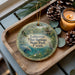 A decorative ornament featuring a scenic image of the Blue Springs State Park in Florida, with a candle and pine cones on a wooden tray.
