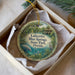 A decorative ornament in a box, featuring an illustration of a manatee and palm trees, with text that reads "Lafayette Blue Springs State Park, Florida".
