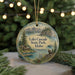 A round ornament featuring a scenic landscape of Lake Cascade State Park, Idaho, with a bird perched on a rock and a cabin in the background.