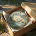 A wooden box containing a decorative ornament with a scenic landscape of Lake Cascade State Park, Idaho.