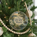 A circular ornament hanging on a Christmas tree, featuring a scenic image of Lake Chicot State Park in Arkansas.