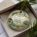 A decorative ornament in a box, featuring a scenic image of Lake Fausse Pointe State Park in Louisiana.