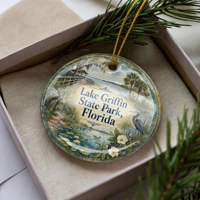 A decorative ornament with a scenic image of Lake Griffin State Park, Florida, featuring a bird, palm trees, and a body of water.