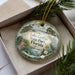 A decorative ornament with a scenic image of Lake Griffin State Park, Florida, featuring a bird, palm trees, and a body of water.