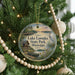 A circular ornament hanging on a Christmas tree, featuring a scenic image of Lake Lowndes State Park in Mississippi.