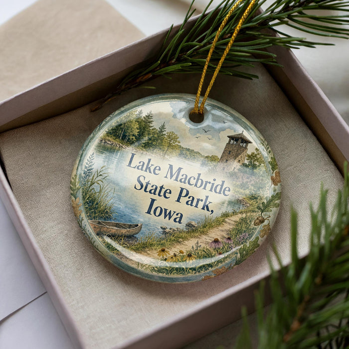 A decorative ornament with a scenic lake and park landscape, featuring a lighthouse and a boat on the water.