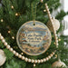 A round ornament hanging on a Christmas tree, featuring a scenic image of Lake Pueblo State Park, Colorado.