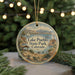 A round ornament with a scenic image of Lake Pueblo, Colorado, featuring a sailboat, mountains, and a cabin.