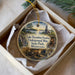 A round ornament with a painting of a mining scene, including a mine entrance, a river, and a sunset, is displayed in a box.