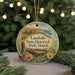 A round ornament with a scenic image of Lapakahi State Historical Park, Hawaii, featuring a wooden structure, flowers, and a body of water.