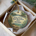 A decorative ornament in a box, featuring a scenic landscape with a lighthouse and trees, along with text that reads "Lime Island State Recreation Area, Michigan".