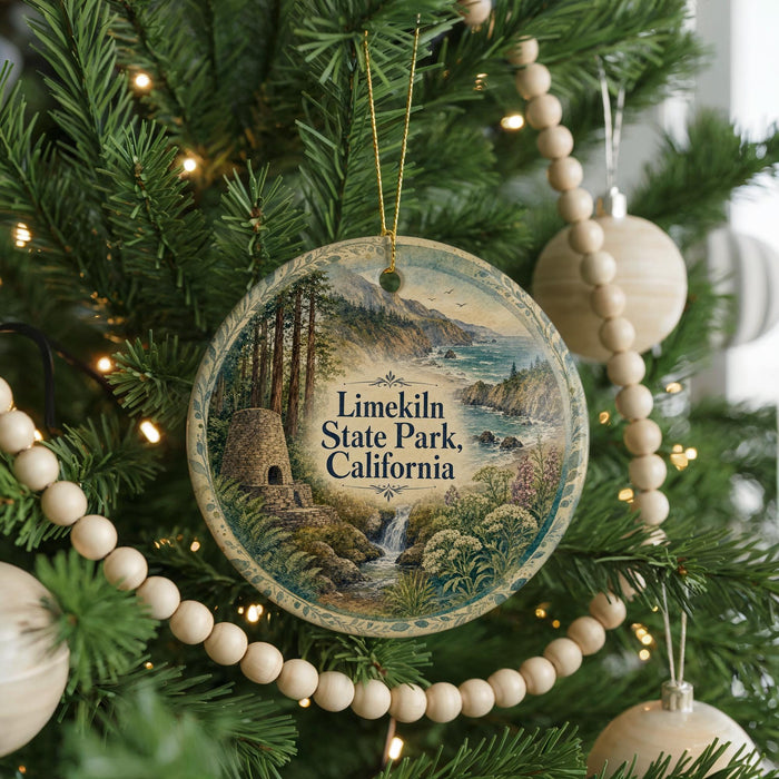 A round ornament hanging on a Christmas tree, featuring a scenic landscape with a waterfall and mountains.