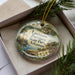 A decorative ornament in a box, featuring a scenic image of Louisiana Purchase State Park, Arkansas.