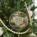 A circular ornament hanging on a Christmas tree, featuring a scenic image of Louisiana Purchase State Park, Arkansas.