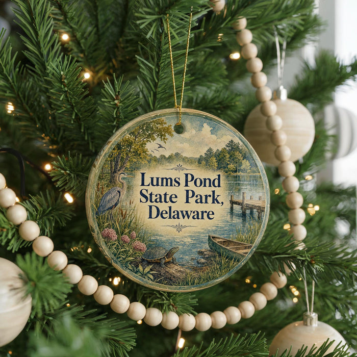 A round ornament hanging on a Christmas tree, featuring a scenic image of Lums Pond State Park in Delaware.