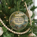 A round ornament hanging on a Christmas tree, featuring a scenic image of Lums Pond State Park in Delaware.