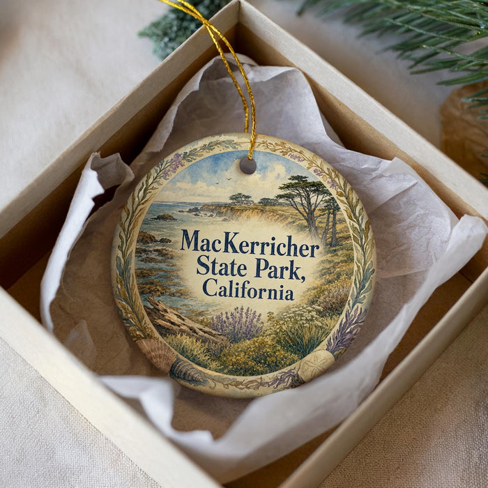 A decorative ornament in a box, featuring a scenic landscape with mountains, trees, and a body of water.
