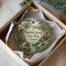 A decorative ornament in a box, featuring a scenic image of Magnolia Springs State Park in Georgia.