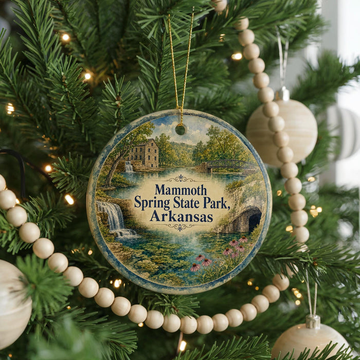 A round ornament hanging on a Christmas tree, featuring a scenic image of Mammoth Spring State Park in Arkansas.